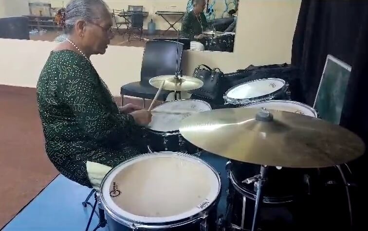 I-Serve member playing drums